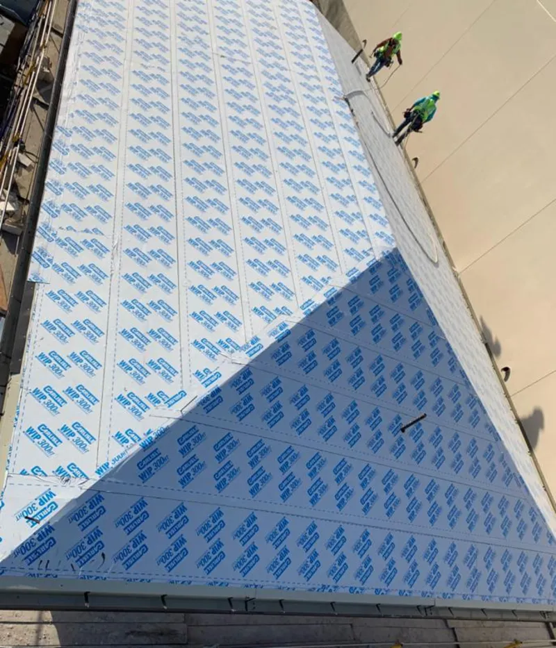 Professional roofers installing underlayment on a metal roof in Cambridge